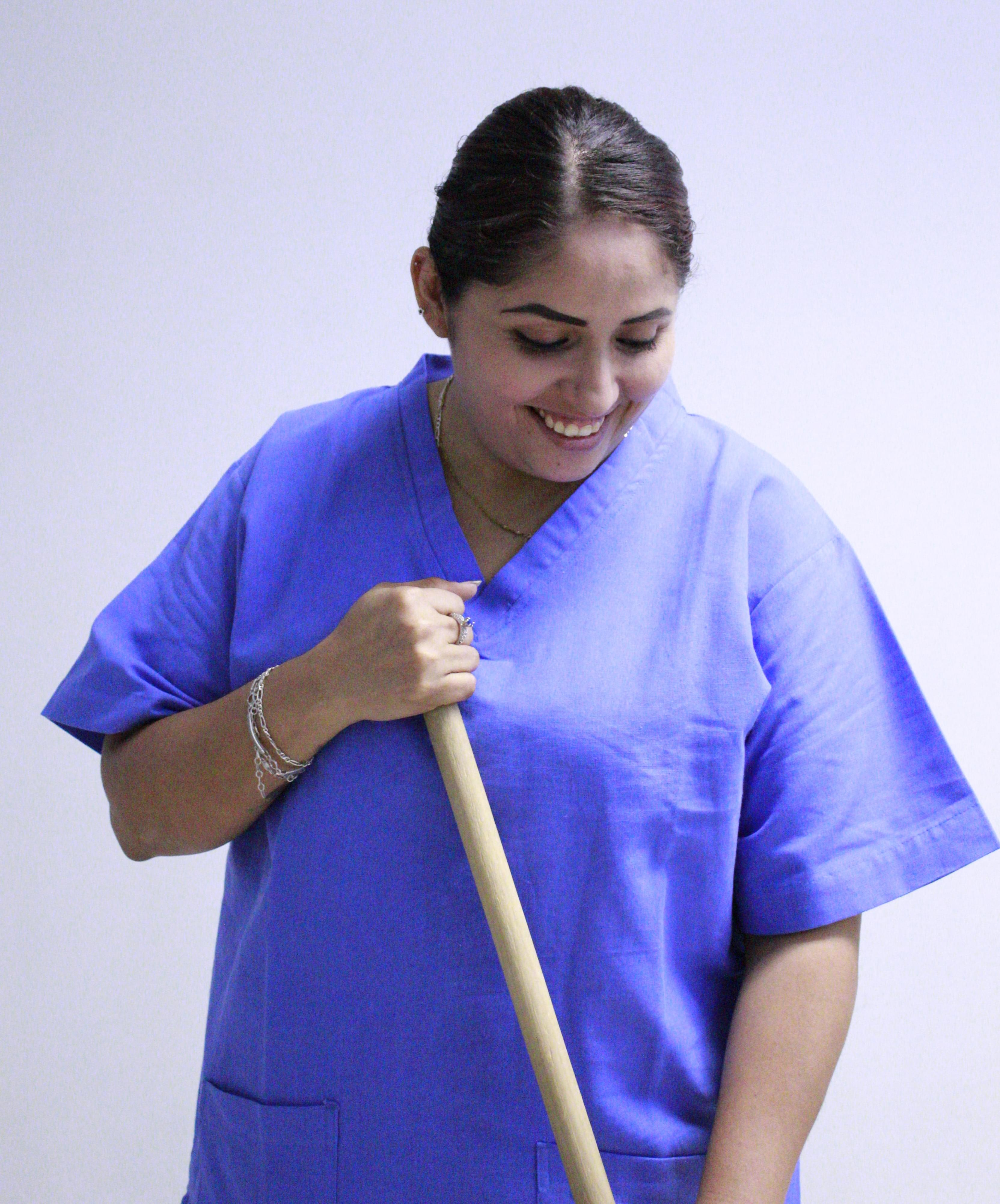 fotografia de una mujer sonriendo mientras barre